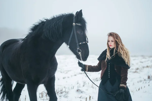 Holka s koněm v poli v zimě — Stock fotografie