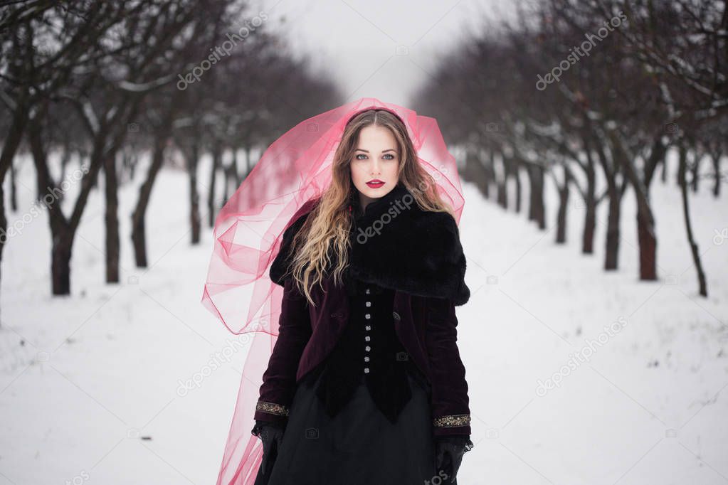 girl in a red veil on the snow in the winter