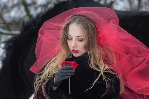 Menina em um véu vermelho na neve no inverno — Fotografia de Stock