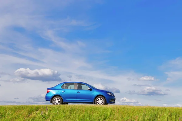 Homel, Fehéroroszország - 2016. június 5.: Renault Logan. Az autó a kék háttérben a természet. — Stock Fotó