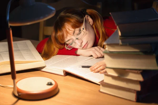 Meisje het lezen van een boek in de bibliotheek onder de lamp — Stockfoto