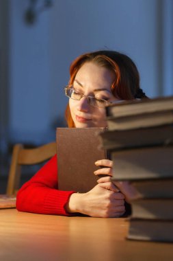 lambanın altında kütüphanede kitap okuyarak kız