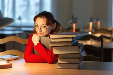 lambanın altında kütüphanede kitap okuyarak kız