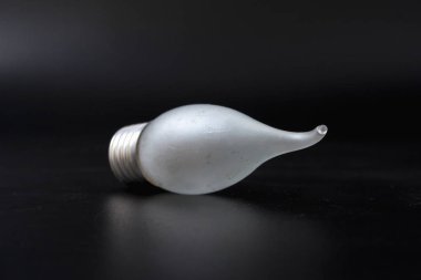 siyah bir arka plan üzerinde ekonomik ampul.