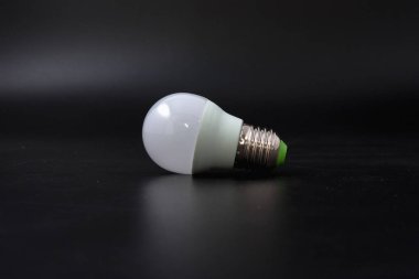 siyah bir arka plan üzerinde ekonomik ampul.