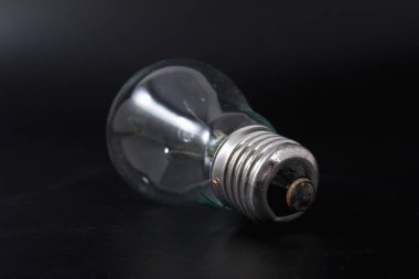 siyah bir arka plan üzerinde ekonomik ampul.