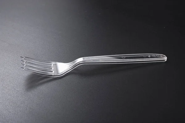 Jednorázové plastové nádobí. vidlička a nůž na černém pozadí. — Stock fotografie