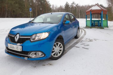 Gomel, Belarus - 21 Şubat 2017: Araba Renault - Logan farlar ile kış ormandaki.