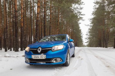 Gomel, Belarus - 21 Şubat 2017: Araba Renault - Logan farlar ile kış ormandaki.