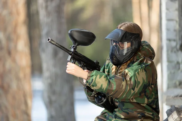 Chica jugando paintball en overoles con un arma . —  Fotos de Stock