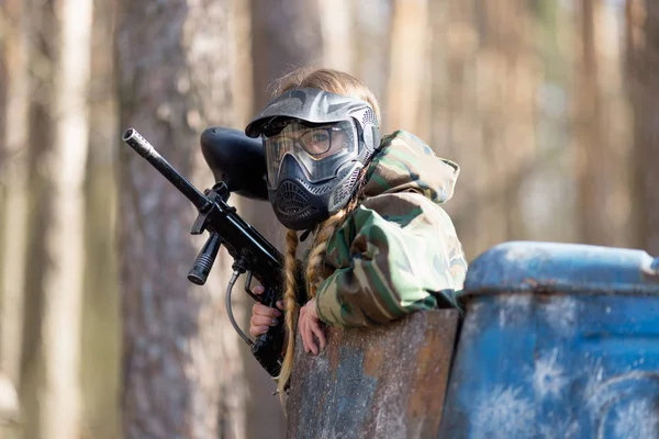 Chica jugando paintball en overoles con un arma . —  Fotos de Stock