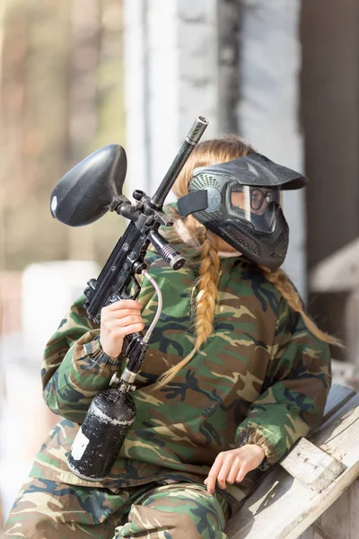 Chica jugando paintball en overoles con un arma . —  Fotos de Stock