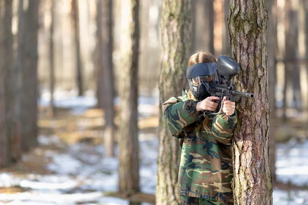 Girl playing paintball in overalls with a gun. — Stock Photo, Image