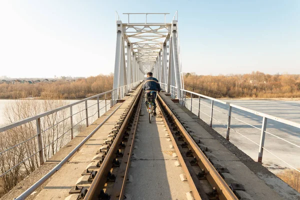 Un hombre montando una bicicleta en el tren en la primavera en la distancia . —  Fotos de Stock