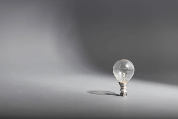 Electric light bulb on a gray background — Stock Photo, Image