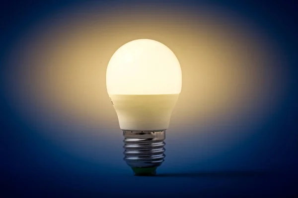 Електрична лампочка на сірому фоні — стокове фото