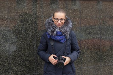 Mermer bir karanlık duvar bir arka plan üzerinde bir kamera ile güzel kız