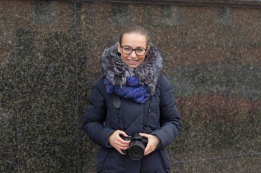 Mermer bir karanlık duvar bir arka plan üzerinde bir kamera ile güzel kız