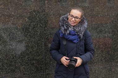 Mermer bir karanlık duvar bir arka plan üzerinde bir kamera ile güzel kız