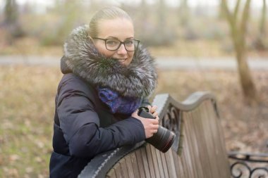 Bir fotoğraf makinesi ile güzel kız parkta yürüyor