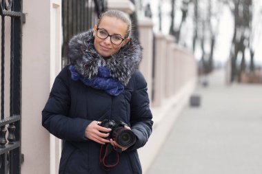 Bir fotoğraf makinesi ile güzel kız parkta yürüyor