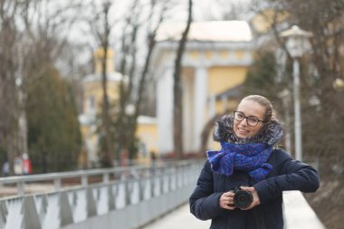 Bir fotoğraf makinesi ile güzel kız parkta yürüyor