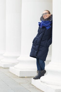 Güzel kız açık havada beyaz sütunlarla neşeli