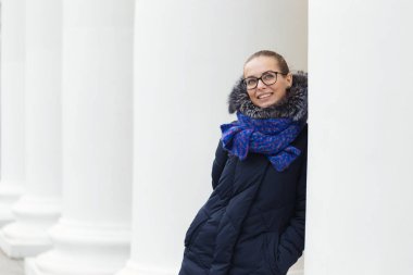 Güzel kız açık havada beyaz sütunlarla neşeli