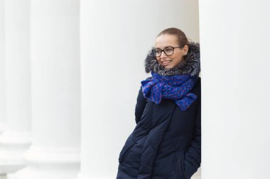 Güzel kız açık havada beyaz sütunlarla neşeli