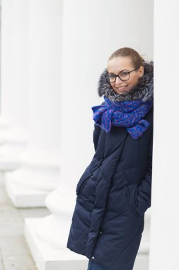 Güzel kız açık havada beyaz sütunlarla neşeli