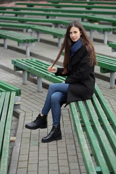 Portret van een mooi meisje op een groen bankje — Stockfoto