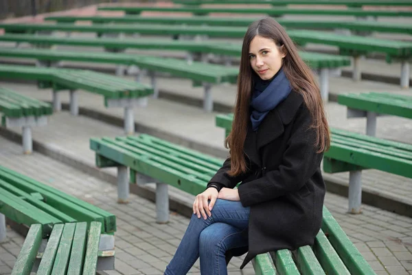 Portret van een mooi meisje op een groen bankje — Stockfoto