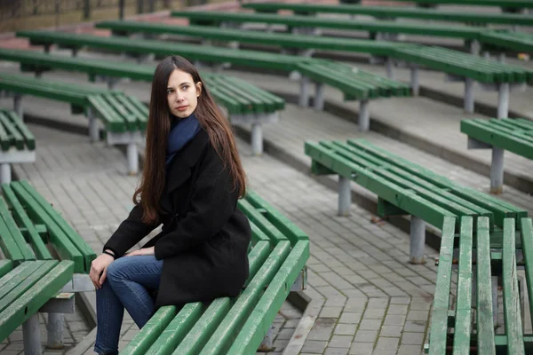 Portret van een mooi meisje op een groen bankje — Stockfoto