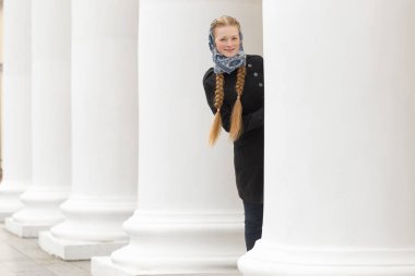 Güzel kız açık havada beyaz sütunlarla neşeli