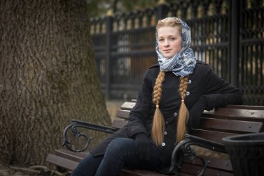 Bir bankta oturan güzel kızıl saçlı kız