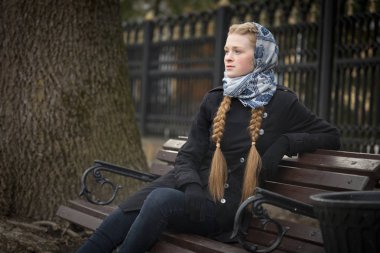 Bir bankta oturan güzel kızıl saçlı kız