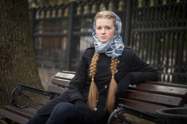 Bir bankta oturan güzel kızıl saçlı kız