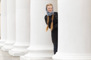 Güzel kız açık havada beyaz sütunlarla neşeli