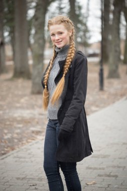 Kızıl saçlı kız doğada örgü saç maşası.