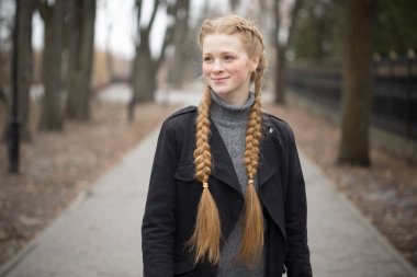 Kızıl saçlı kız doğada örgü saç maşası.