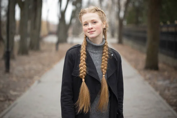 Rödhårig flicka med flätor våren i naturen. — Stockfoto