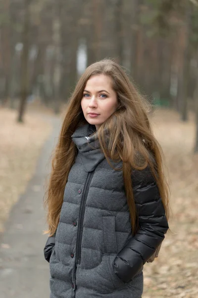 Portret van een meisje in een grijze jas in de open lucht — Stockfoto