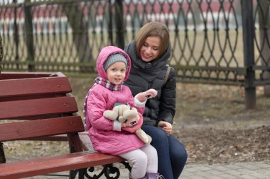 Anne ve kızı bir bankta oturuyor