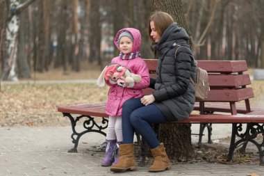Anne ve kızı bir bankta oturuyor