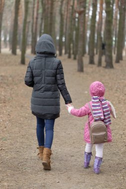 Anne ve kızı parkta elinde çevresinde yürüyüş