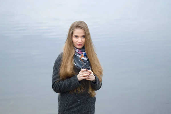 Portrait of a beautiful girl in early spring outdoors by the water — Stock Photo, Image