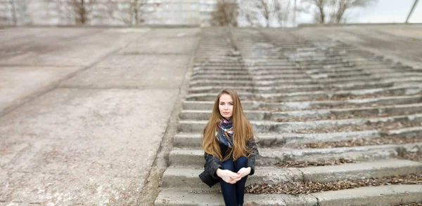 Portrait of a beautiful girl in early spring on the steps — Stock Photo, Image