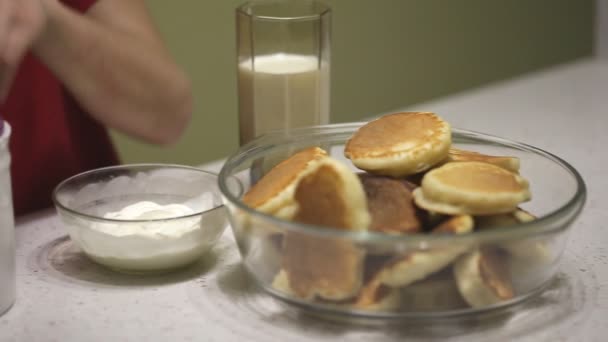 Um adolescente come panquecas com creme azedo — Vídeo de Stock