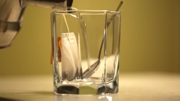 Una bolsa de té en un vaso de agua limpia — Vídeos de Stock