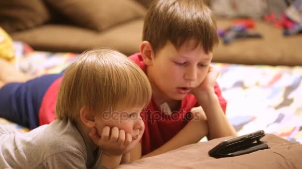 Kinderen in pyjama kijken naar tekenfilms op de telefoon — Stockvideo